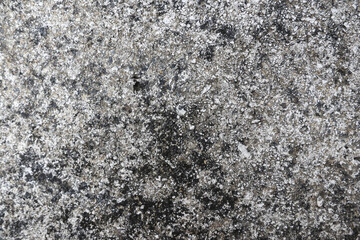 Detailed close up of fine granular ash creates rough textured surface. Monochrome tones of grey,...