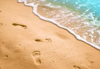 Footprints in the sand and a blue ocean