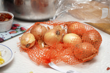 Fresh onions in a mesh bag on a kitchen counter ready for cooking