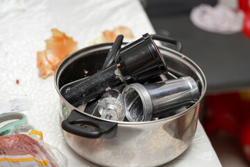 Kitchen utensils and tools in a stainless steel pot after meal preparation in a home kitchen setting