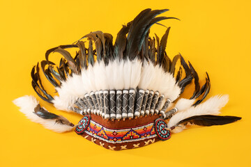 Traditional warbonnet (Native American chief headdress) on yellow background