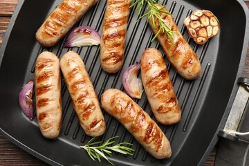 Pan with grilled sausages and spices on table, top view
