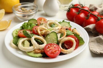 Delicious salad with squid rings and ingredients on white table, closeup