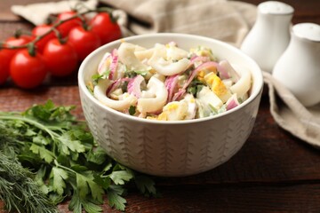 Tasty salad with squid rings, onion and eggs served on wooden table, closeup