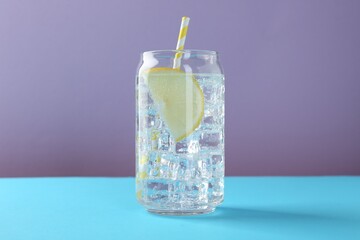 Refreshing water with lemon and ice on color background