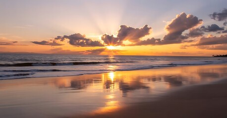 Golden sunset over the ocean with dramatic clouds and reflections on wet sand