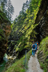 Fototapeta premium Hiking Group On Spectacular Trail Triftsteig Through Canyon Tiefenbachklamm With Brandenburger Ache In Tyrol, Austria