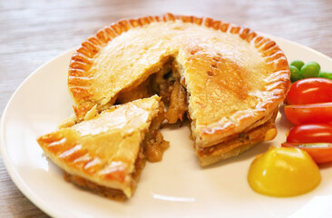 Closeup of mouthwatering beef pie served with fresh veggies