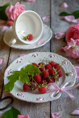 A cup of aromatic tea, a book and a rose on the table.