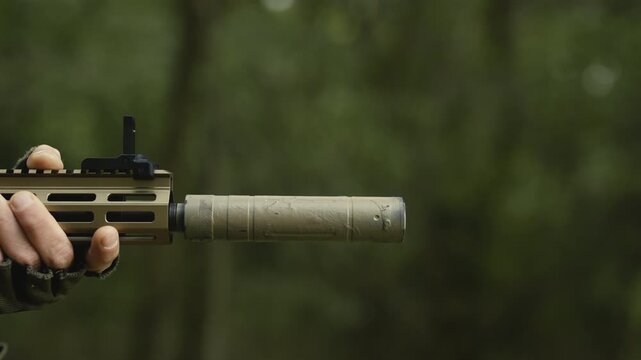 Soldier with AR15 carbine on a mission. Close-up rifle with a collimator shooting a bullet