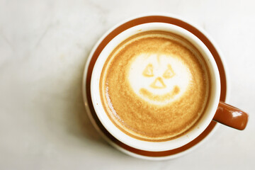 Frothy cappuccino coffee with Jack O' Lantern latte art