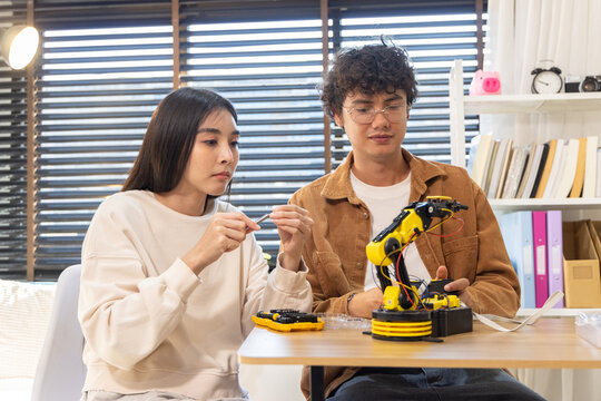 Young couple building robotic arm at home