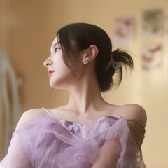 Elegant woman in a lavender dress posing gracefully indoors.