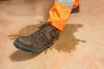 An industrial, manufacturing, safety topic. A worker slipping on liquid.