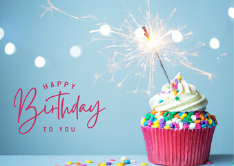 A festive birthday cupcake with a sparkler on a blue background.
