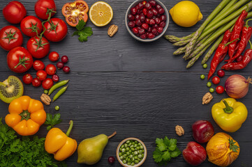 Fresh colorful assortment of fruits and vegetables including tomatoes, kiwi, bell peppers, berries, and greens on a dark wooden background, promoting healthy eating, organic living, and vibrant nutrit