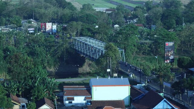 Kediri, Indonesia - August 17, 2024: Madiun city landscape in the morning. Bridges, highways, motorcyclists and houses

