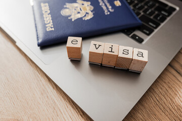 E-visa wooden letter blocks and United States passport on laptop keyboard
