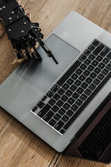 Robotic hand typing on laptop keyboard, concept of artificial intelligence and automation