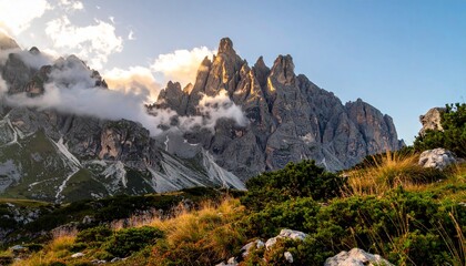 Majestic jagged mountain peaks bathed in warm golden sunlight, with ethereal clouds swirling around their dramatic rocky faces, a breathtaking alpine vista inspiring awe and adventure.