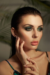 model displays stunning makeup with artistic eyeshadow and flawless skin. She poses gracefully with a thoughtful expression, highlighting her beauty. soft background enhances her features