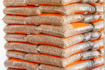 Wood pellets in bags, neatly stacked, presenting a renewable biomass energy source for heating