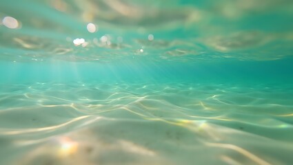 Underwater view of turquoise ocean water with sunlight and sandy seabed