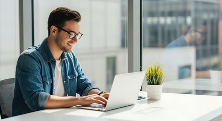 Smiling young man using laptop computer working from home office
