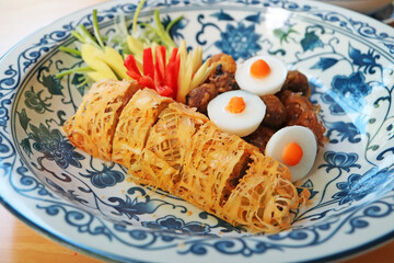 Stuffed sweet peppers with ground pork wrapped in fried lacy egg wrap, one of the essential side dishes of Khao Chae, a popular Thai summer refreshment