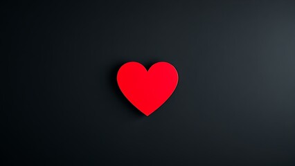 A striking red heart on a textured black background, representing deep emotions and minimalist beauty.