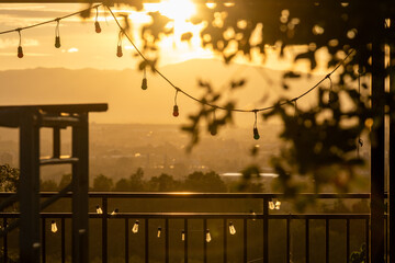 Nature travel background image, golden light hits the light bulbs hanging on the fence in the evening.