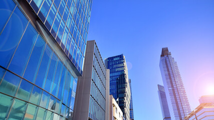 Fototapeta premium Bottom up view of modern glass office building. Commercial real estate. New commercial office building in modern city.