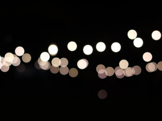 A mesmerizing array of soft, circular bokeh lights glowing against a deep black background, creating a serene and dreamy abstract visual effect.