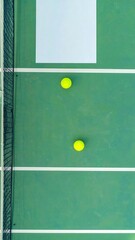High-angle view of a tennis court with two yellow balls
