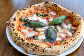 Sour dough pizza flat bread with mozzarella cheese, tomatoes and basil leaves Margarita, Napels street food, Italy