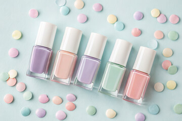 Pastel nail polish bottles with candy isolated on white background