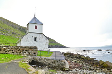 Historic White Saint Olav&rsquo;s Church Overlooking the Atlantic Ocean in Kirkjubour Village, Faroe Islands