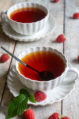 For breakfast, there are toasts with fruits and berries and a cup of aromatic tea on the table.