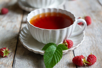 For breakfast, there are toasts with fruits and berries and a cup of aromatic tea on the table.