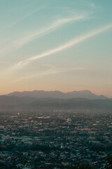 Scenic View of City and Mountains at Dusk