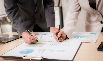 A young businessman is showing something to his colleagues on his work laptop screen. Colleagues are discussing new projects or startups and analyzing the company's performance.