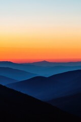 Obraz premium Layers of Blue Mountains Against a Gradient Orange and Yellow Sunset Sky landscape nature