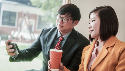 A young businessman is showing something to his colleagues on his work laptop screen. Colleagues are discussing new projects or startups and analyzing the company's performance.