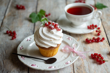 Red currant cake and a cup of aromatic tea in a porcelain cup on the table.