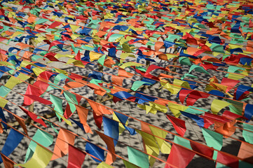Decorative pennant flags on strings forming a continuous texture of blue, orange, blue, and yellow colors