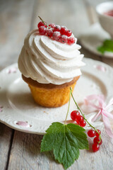 Red currant cake and a cup of aromatic tea in a porcelain cup on the table.