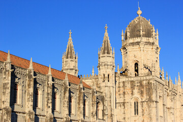 Fototapeta premium Portugal, Lisbon, Belem. Hieronymites Monastery - Mosteiro dos Jeronimos. Built in Gothic - Manueline style. One of Lisbon's most visited monuments. Lit by late afternoon sunshine. UNESCO listed.