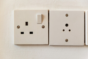 Electrical outlet Britiosh system on wall close up