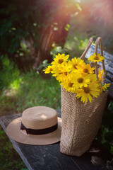 Wild flowers in a beautiful straw bag and a straw hat.