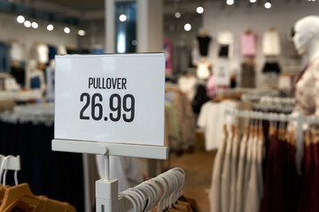 Preisschild an einem Kleiderständer mit der Aufschrift Pullover 26,99